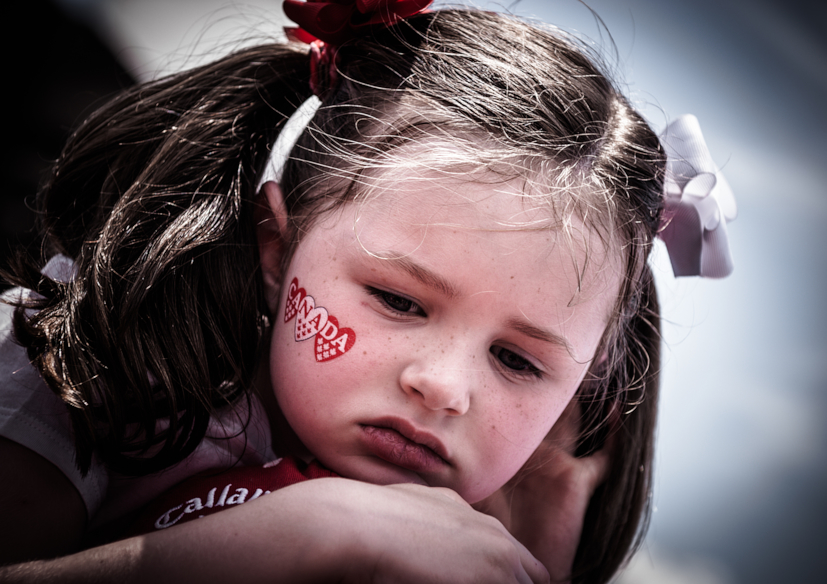 tired girl with bow ties and canada day face sticker