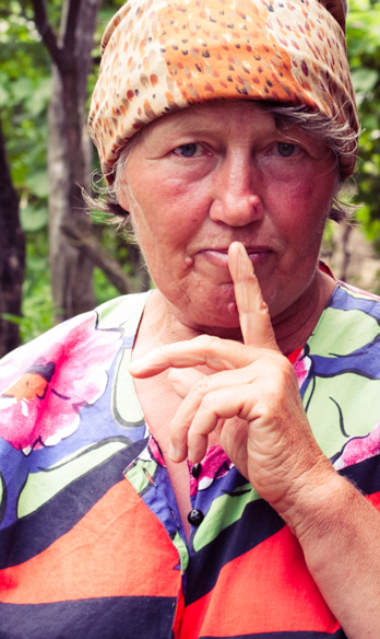 elderly woman making shh gesture