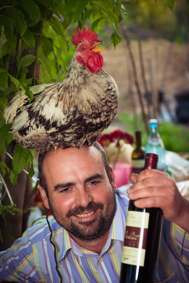 man with rooster on head